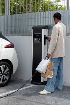 Black man charging his electric car