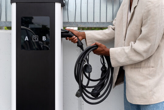 Black man charging his electric car