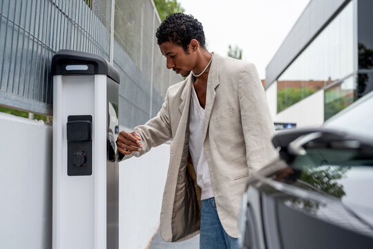 Man using smartwatch to pay at recharging station 