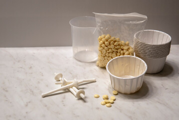 Nose wax kit. Wax set for nose hair removal. Dry wax beads, paper cups with applicator sticks for nose depilation on the white background 