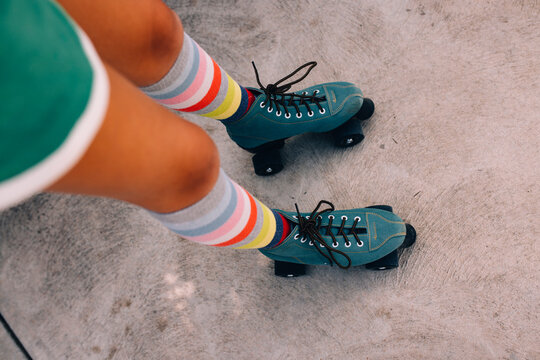 Looking down at roller skates and striped socks. 