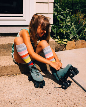 Young girl in green shorts and green roller skates