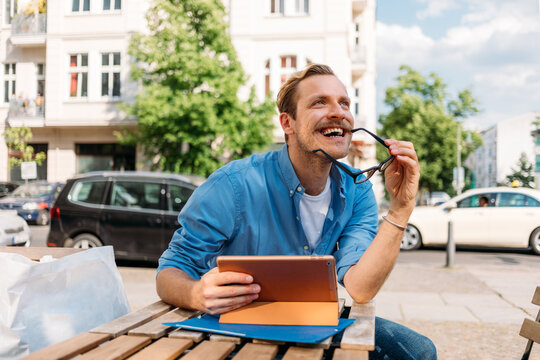 Man Sitting in Cafe and Using Tablet