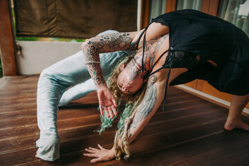 young hippie couple practicing yoga at home. together like a dance