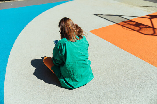 A girl on the playground for a basketball.