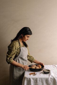 Young woman holding pan of sourdough cinnamon buns