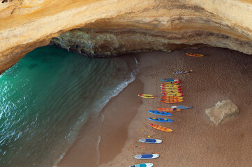Paddleboards on sandy seashore near cliffs in Portugal