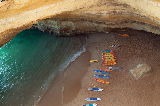 Paddleboards on sandy seashore near cliffs in Portugal