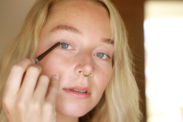 young woman applying eyeliner