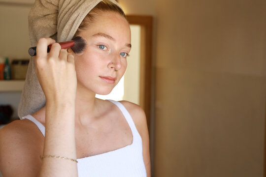 young woman applying make-up