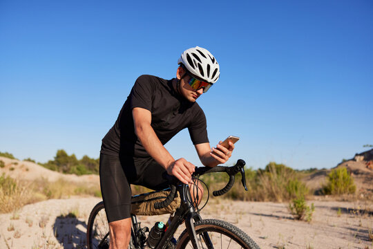 Male cyclist using smartphone on bike