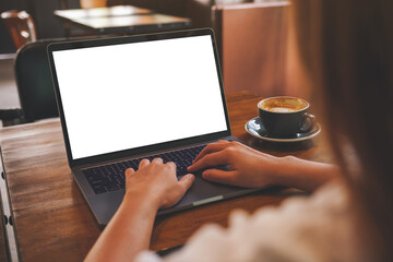 Mockup image of a woman using and typing on laptop computer with blank white desktop screen in cafe