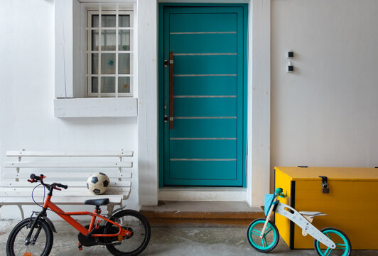 Vibrant color photo of the home front door with  the kid's bicycle