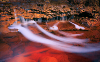 Abstract landscape of rocks in red river water