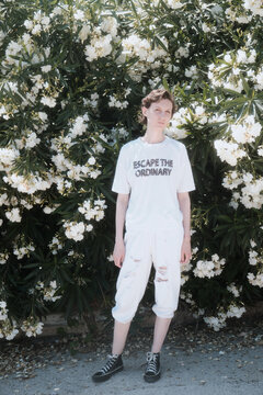 Woman in the sun near a flowering bush
