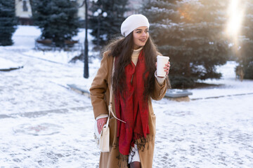 beautiful girl with coffee in her hands rushes to a meeting with his girlfriend in the city center