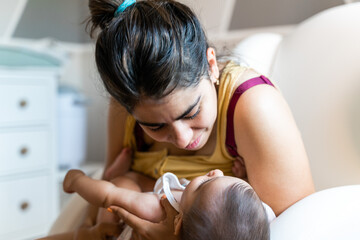 mother looks sweetly at her baby in the nursing chair
