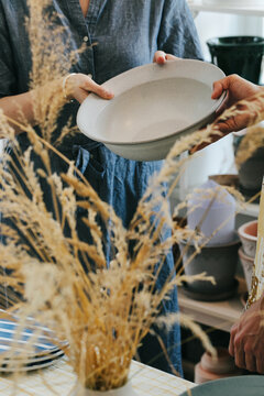 Faceless Shop Assistant Selling Ceramic Bowl to Customer