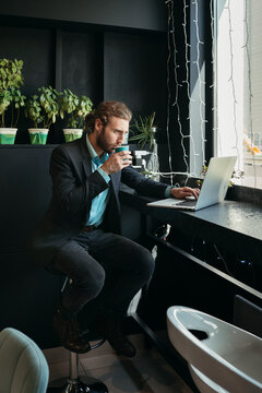 Modern man drinks coffee in cafe.