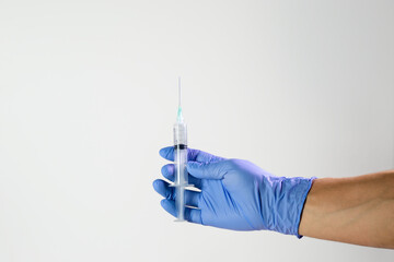 Manos de doctor con guantes quirúrgicos, medicinas y jeringas en diferentes acciones en fondo...