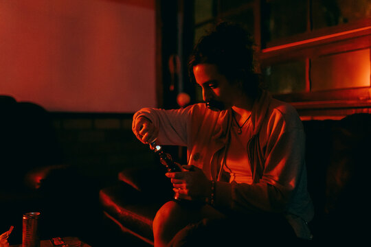 Woman lighting a bong at home