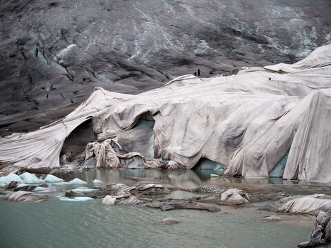 Anthropogenic global warming melting covered Rhone Glacier Swiss Alps