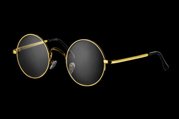 Classic gold round glasses isolated on black.