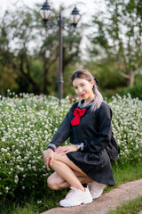 Woman wearing cosplay Japanese school uniform at park outdoor.