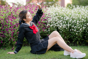 Woman wearing cosplay Japanese school uniform at park outdoor. - obrazy, fototapety, plakaty