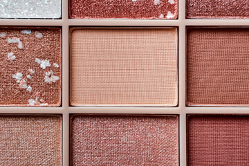 Fototapeta premium Eyeshadow colorful shades palette in beige tones close-up. Beauty abstract background.