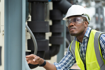 African American male plumber worker check or maintenance sewer pipes network system at construction site