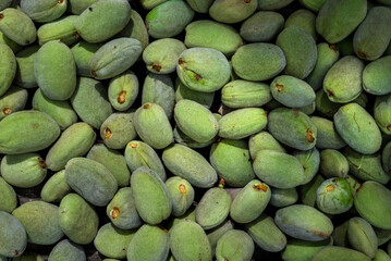 Green almonds background   fresh raw unripe wooden rustic table blurred garden background leaves, Top view concept with copy space shell  tree branch pattern texture