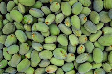 Green almonds background   fresh raw unripe wooden rustic table blurred garden background leaves, Top view concept with copy space shell  tree branch pattern texture