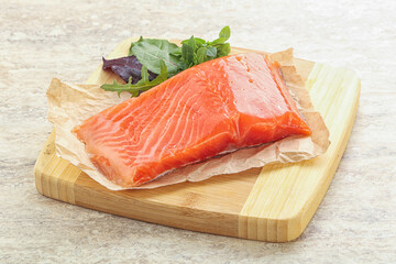 Raw salmon fillet over board