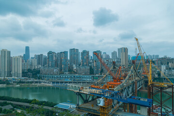 This is Chongqing, China, where a bridge is being built over a large river. This bridge will connect the two sides of the river and make the traffic more convenient. 