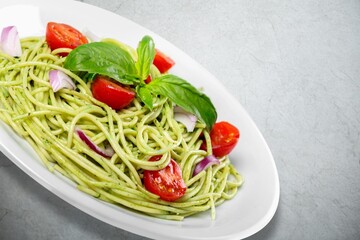 Tasty noodles dish on the plate on the desk.