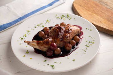 Baked rabbit with red wine sauce and grapes.