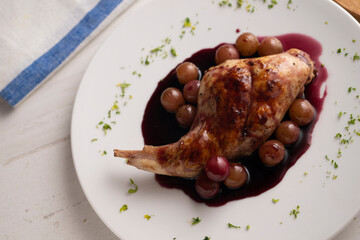 Baked rabbit with red wine sauce and grapes.