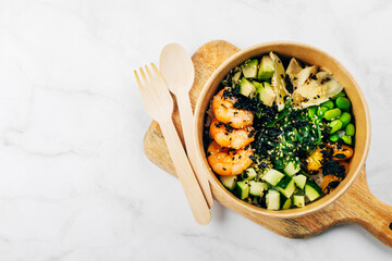 Shrimp poke bowls with seaweed, avocado, mango, cucumber, rice, pickled ginger, sesame seeds.