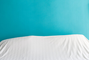 White duvet cover with space on blue wall background, bed room background