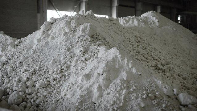 Warehouse storage of raw materials for production. A pile of prepared white clay.