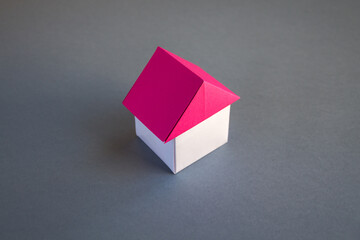 White and red paper house origami isolated on grey background
