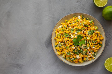 Homemade Mexican Street Corn Esquites on a Plate on a gray background, top view. Flat lay, overhead, from above. Copy space.
