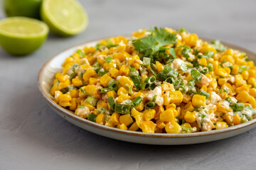 Homemade Mexican Street Corn Esquites on a Plate on a gray background, side view. Close-up.