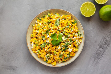 Homemade Mexican Street Corn Esquites on a Plate on a gray surface, top view. Flat lay, overhead, from above.
