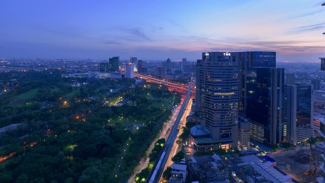 4k Time lapse of sunrise from aerial view of Bangkok city overlook house, road, sky train and high rise building,  Tourist destination in Thailand.