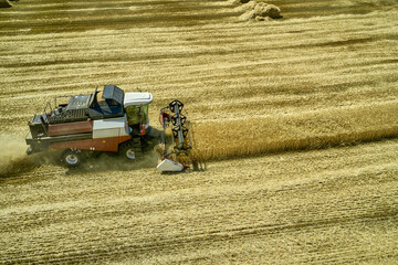 Fototapeta na wymiar a combine harvester harvesting a field of wheat rural landscape