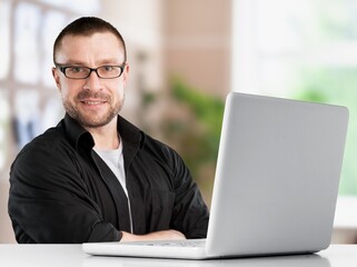 A man working in office with laptop on desk