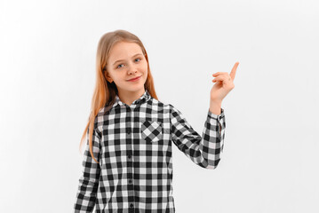 Portrait of happy cute teen girl pointing finger up. Caucasian girl showing top promo deal, upwards advertisement, standing over white background