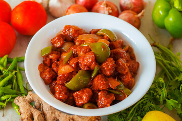 selective focus of Soya Manchurian/Chili Soya bean chunks recipe. with a decorative background.